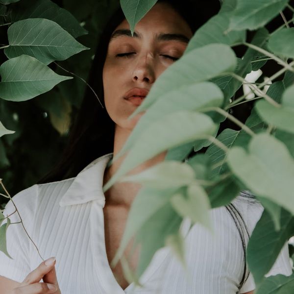 Woman meditating peacefully in a softly lit environment.